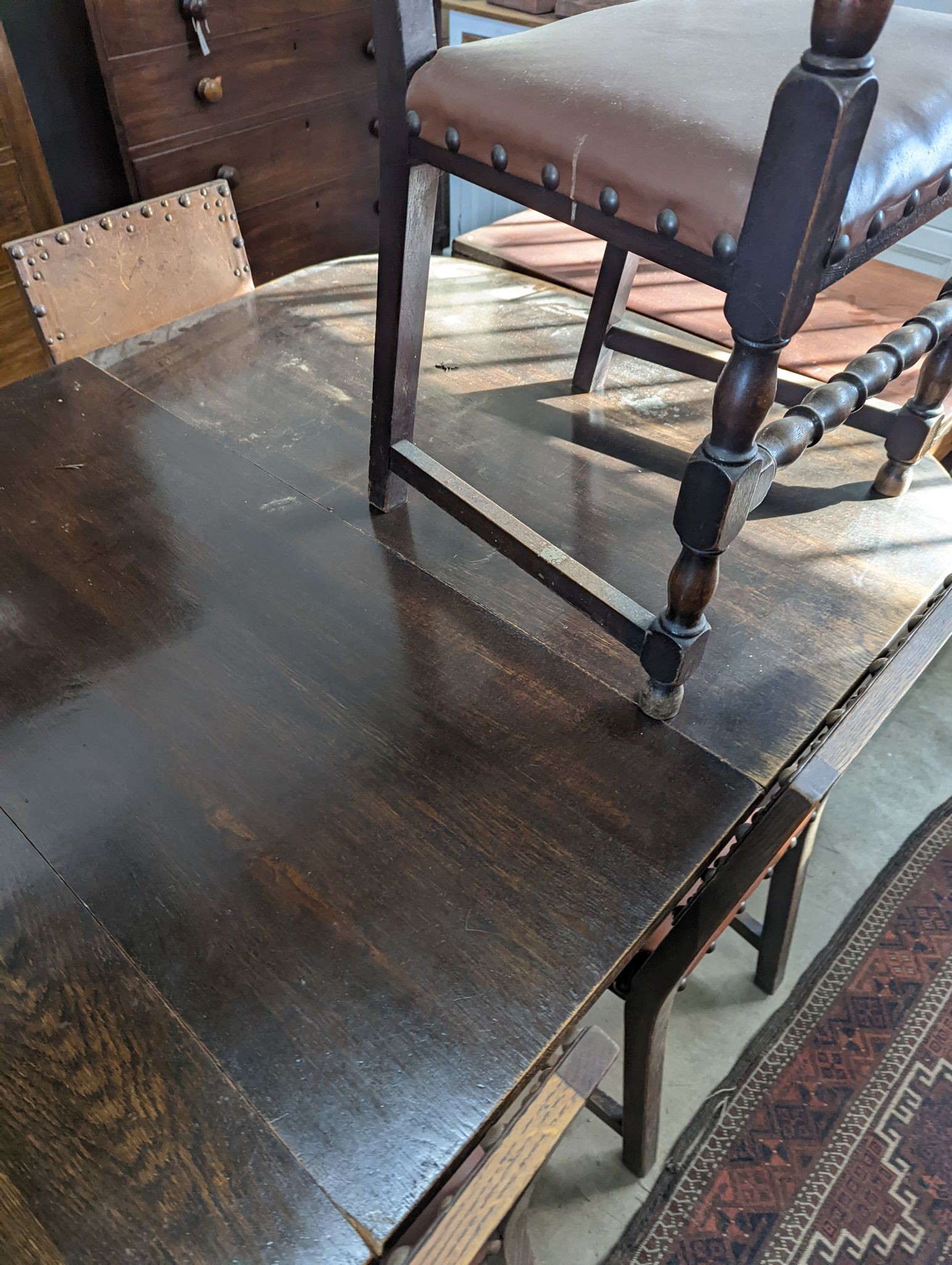 A 1920's oak extending dining table, 238cm extended (two spare leaves), width 120cm, height 74cm together with seven oak dining chairs (one with arms)